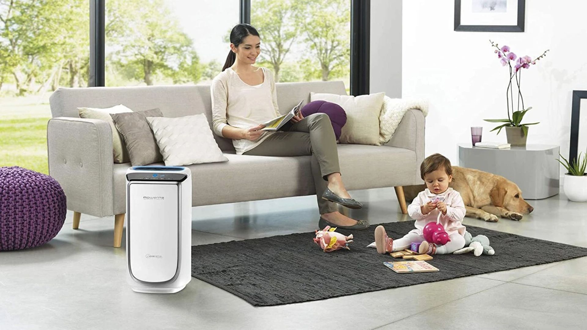 Mujer ventilando salón con purificador HEPA encendido y planta verde al fondo.