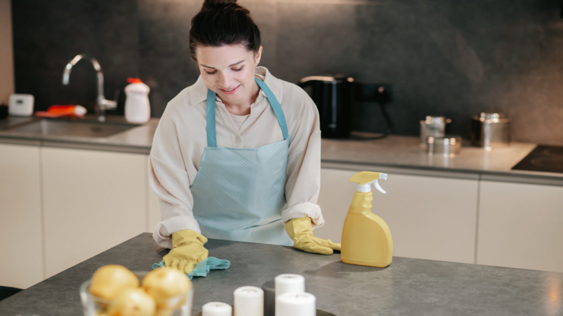 mujer aplicando limpieza probiótica en casa sobre encimera de cocina