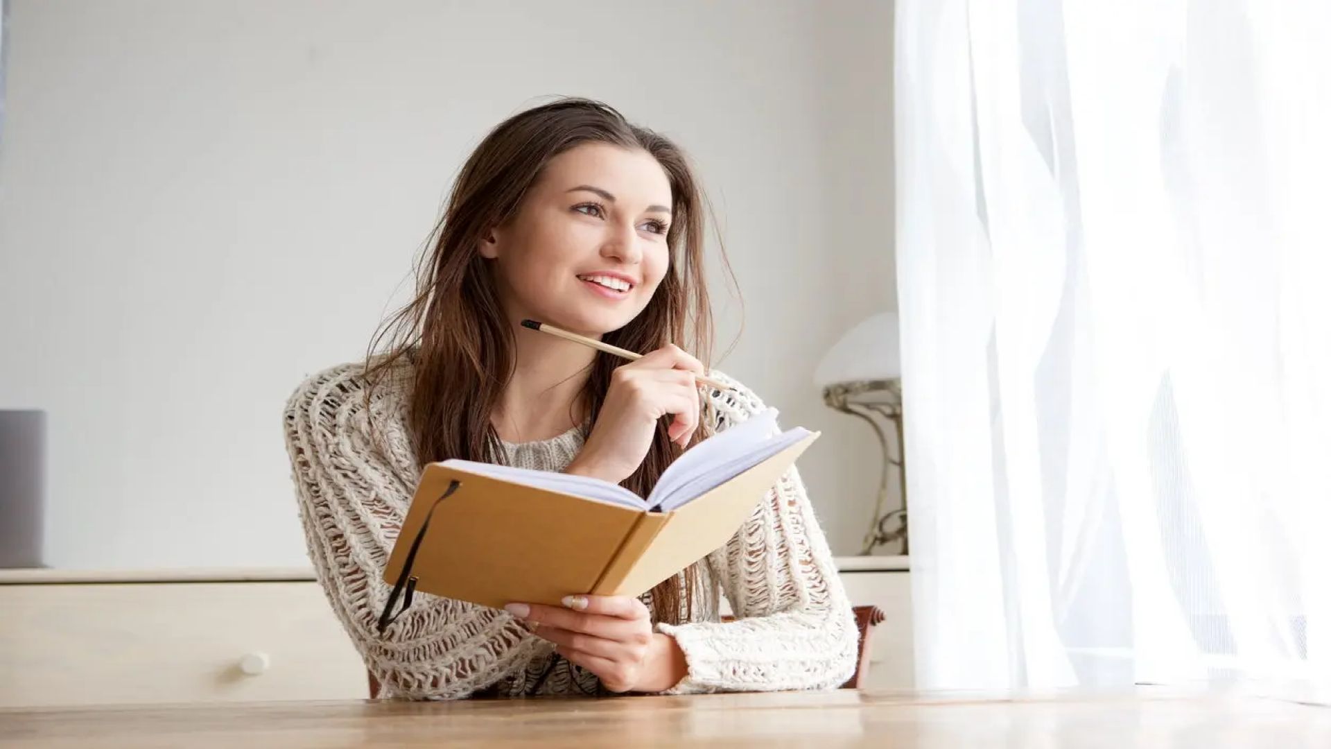 mujer escribiendo en su diario de gratitud antes de dormir