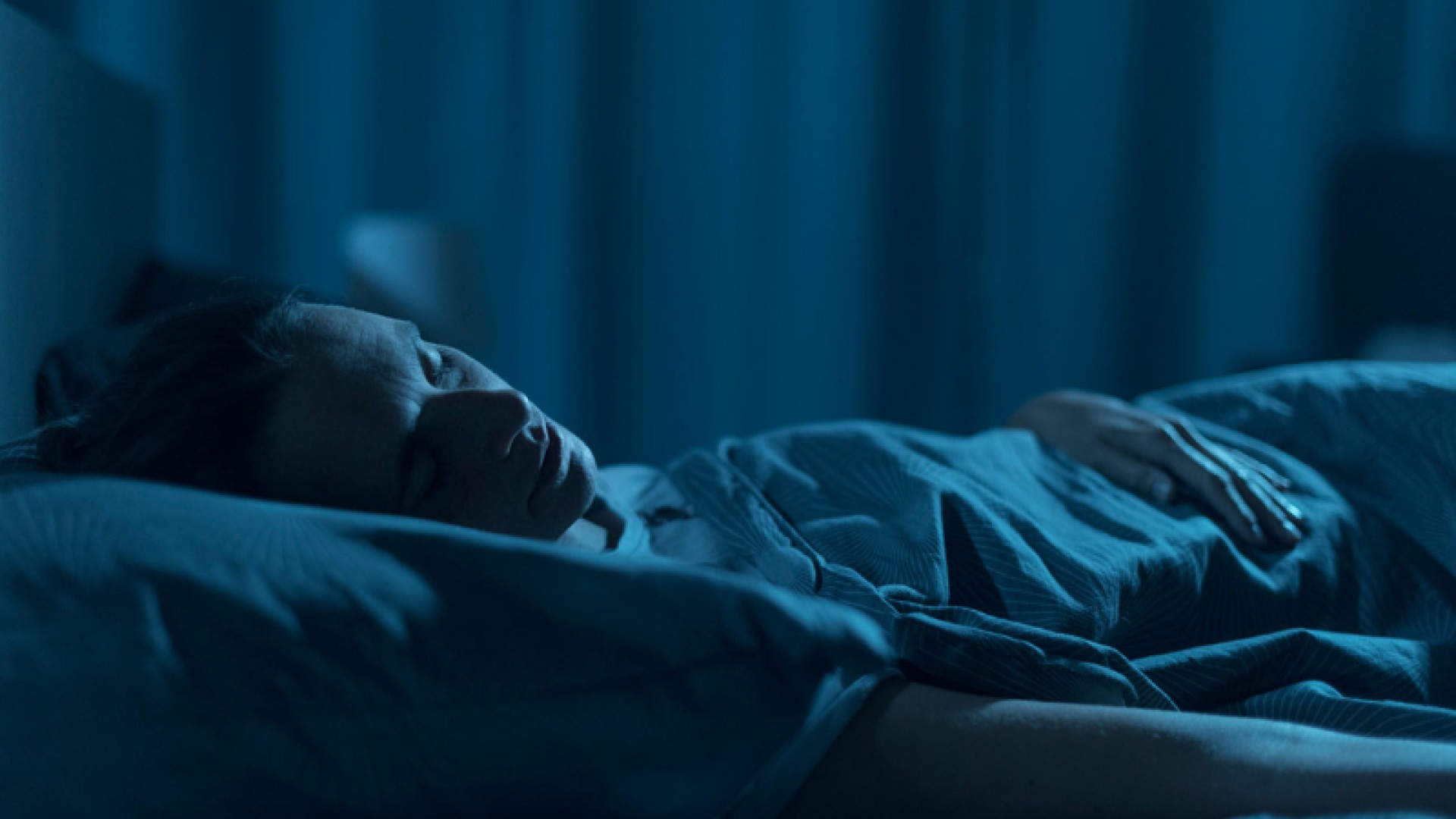 mujer durmiendo plácidamente sobre colchón inteligente con sensores